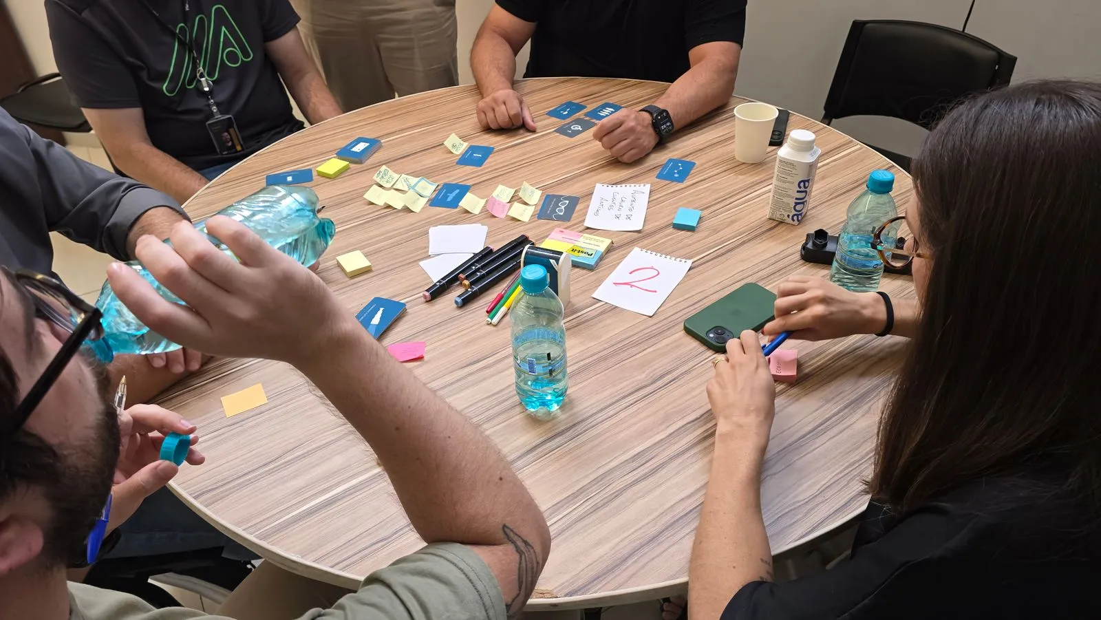 A team gathered around a table covered in sticky notes during a campaign brainstorming session, illustrative of the planning work behind an integrated program.