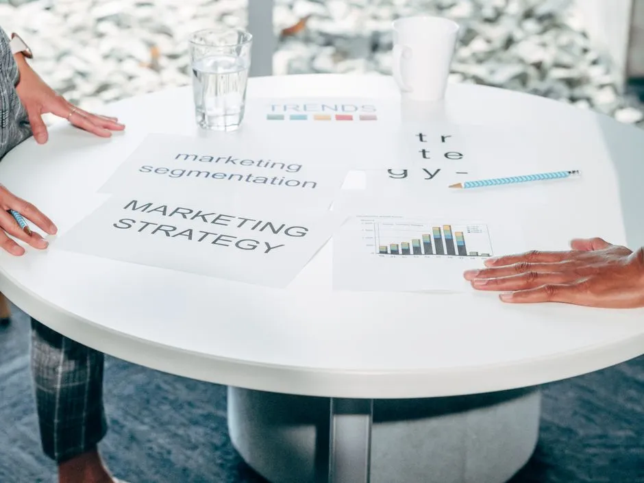 Two people reviewing printed strategy documents spread across a table, illustrative of the agency-briefing work an IMC directory supports.
